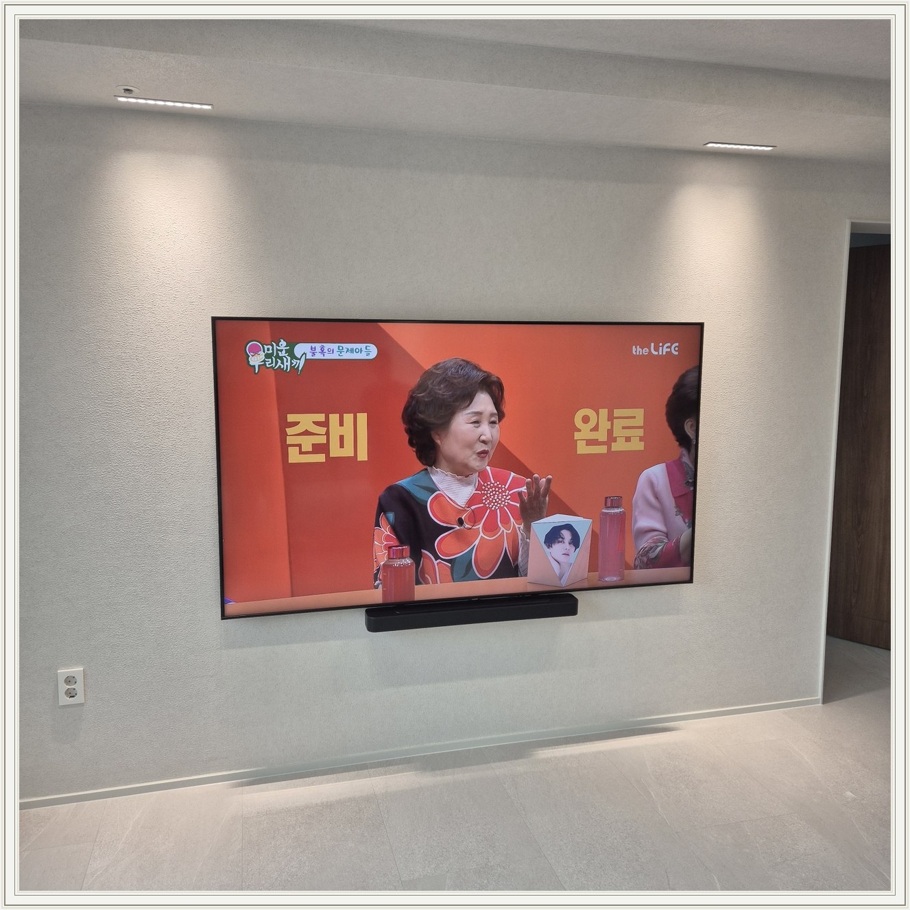 조명이 비추는 미색 벽과 사운드바 / 사운드바와 벽면의 간격이 한눈에 들어옵니다